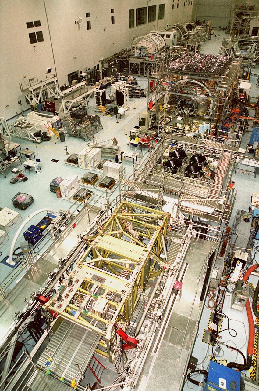 KENNEDY SPACE CENTER, FLA. -- The floor of the Space Station Processing Facility is filled with racks and hardware for testing the various components of the International Space Station (ISS). The large module in the center of the floor (top) is the U.S. Lab, Destiny. The U.S. Laboratory module continues a long tradition of microgravity materials research, first conducted by Skylab and later Shuttle and Spacelab missions. Destiny is expected to be a major feature in future research, providing facilities for biotechnology, fluid physics, combustion, and life sciences research. It is scheduled to be launched on mission STS-98 (no date determined yet for launch). At top left are the Multi-Purpose Logistics Modules Raffaello and Leonardo and the Pressurized Mating Adapter-3 (PMA-3). Italy's major contributions to the ISS program, Raffaello and Leonardo are reusable logistics carriers to resupply and return Station cargo requiring a pressurized environment. They are slated as payloads on missions STS-102 and STS-100, respectively. Dates have not yet been determined for the two missions. The PMA-3, once launched, will be mated to Node 1, a connecting passageway to the living and working areas of the Space Station. The primary purpose of PMA-3 is to serve as a Shuttle docking port through which crew members and equipment will transfer to the Space Station during later assembly missions. PMA-3 is scheduled as payload on mission STS-92, whose date for launch is not yet determined