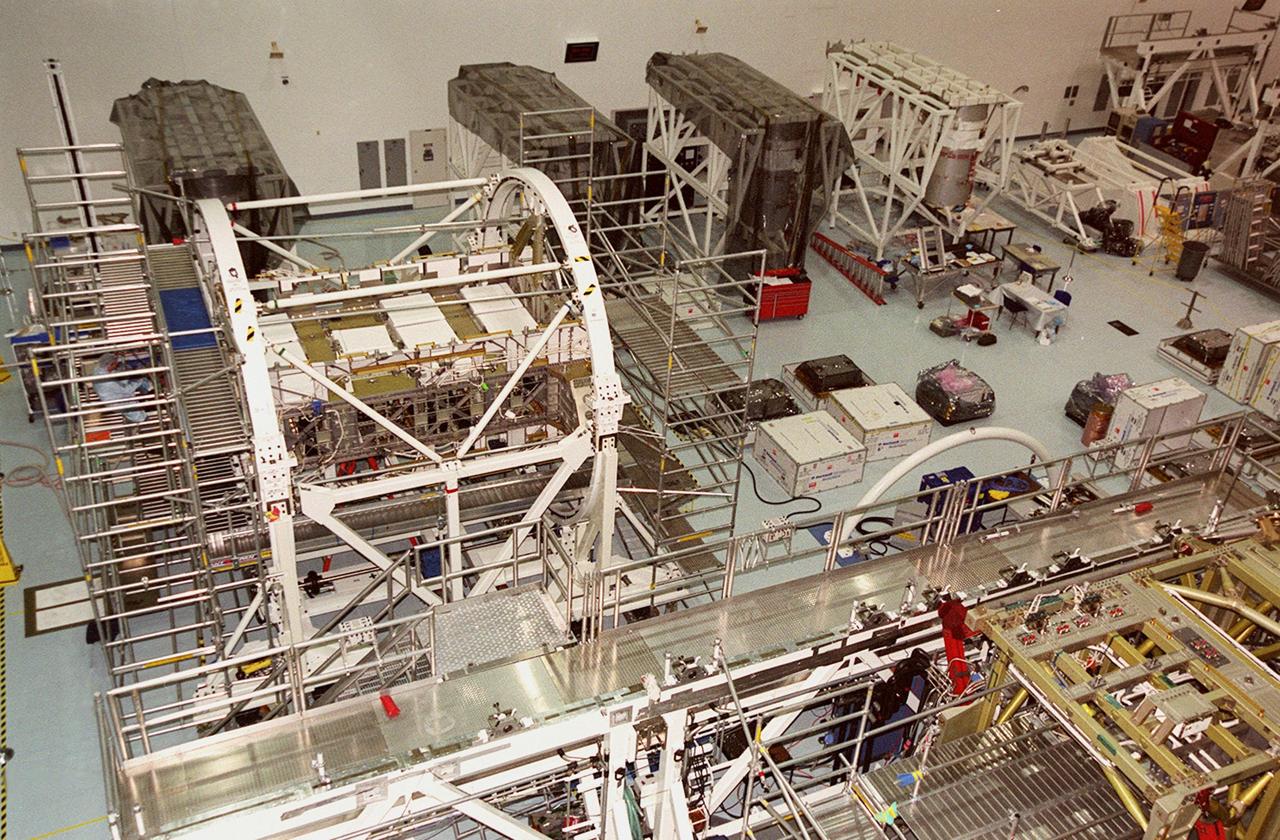 KENNEDY SPACE CENTER, FLA. -- The floor of the Space Station Processing Facility is filled with racks and hardware for testing the various components of the International Space Station (ISS). The large module in the center of the floor (top) is the U.S. Lab, Destiny. Expected to be a major feature in future research, Destiny will provide facilities for biotechnology, fluid physics, combustion, and life sciences research. It is scheduled to be launched on mission STS-98 (no date determined yet for launch). At top left are the Multi-Purpose Logistics Modules Raffaello and Leonardo and the Pressurized Mating Adapter-3 (PMA-3). Italy's major contributions to the ISS program, Raffaello and Leonardo are reusable logistics carriers to resupply and return Station cargo requiring a pressurized environment. They are slated as payloads on missions STS-102 and STS-100, respectively. Dates have not yet been determined for the two missions. The PMA-3, once launched, will be mated to Node 1, a connecting passageway to the living and working areas of the Space Station. The primary purpose of PMA-3 is to serve as a Shuttle docking port through which crew members and equipment will transfer to the Space Station during later assembly missions. PMA-3 is scheduled as payload on mission STS-92, whose date for launch is not yet determined