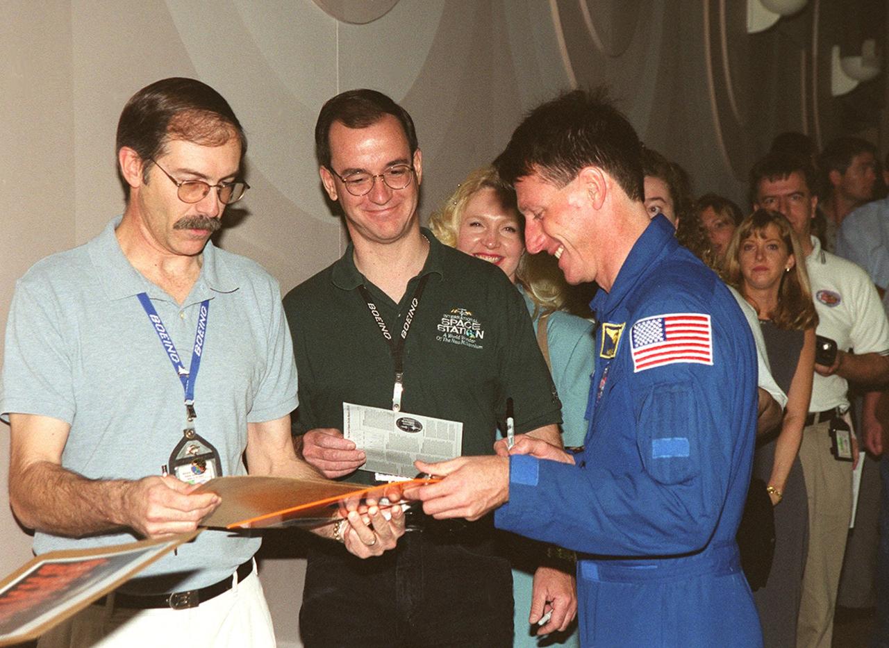 STS-103 Mission Specialist Michael Foale autographs mementos for Boeing-KSC employees. Foale and other crew members gave a presentation at the Center for employees and VIPs about their mission to service the Hubble Space Telescope. STS-103 launched Dec. 19, 1999, and landed Dec. 27, 1999, after a successful mission that included three space walks