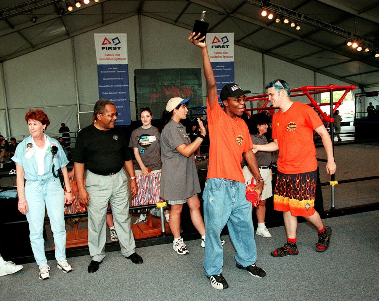 Members of the team known as Heatwave, from St. Petersburg, Fla., are excited after receiving an award at the FIRST (For Inspiration and Recognition of Science and Technology) Southeast Regional competition held at the KSC Visitor Complex. At left are Carol Cavanaugh, Public Affairs, and Nap Carroll, chief financial officer, Kennedy Space Center. Heatwave came in second for the final competition, plus received awards for Number One Seed, Best Offensive round, and the DaimlerChrysler Team Spirit. Teams of high school students from all over the country tested the limits of their imagination using robots they designed, with the support of business and engineering professionals and corporate sponsors, to compete in a technological battle against other schools' robots. Of the 30 high school teams competing at the Southeast Regional event, 16 were Florida teams co-sponsored by NASA and KSC contractors. Local high schools participating are Astronaut, Bayside, Cocoa Beach, Eau Gallie, Melbourne, Melbourne Central Catholic, Palm Bay, Rockledge, Satellite, and Titusville