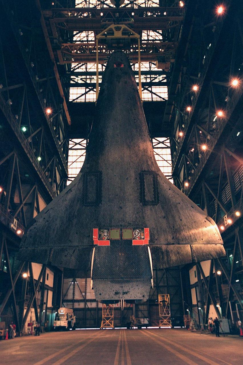 KENNEDY SPACE CENTER, FLA. -- In the transfer aisle of the Vehicle Assembly Building (VAB), the orbiter Atlantis hangs suspended vertically from an overhead crane. Shown is the underside of the orbiter. The black-outlined rectangles near the wings are the location of the main landing gear doors. At the lower end, the two squares centered between the red corners are two of the connection points for the external tank. Another connection is at the top of the underside, between the two red areas shown there. The 122-foot-long orbiter is easily accommodated inside the 525-foot-tall, 518-foot-wide VAB. Atlantis will be mated with its external tank and solid rocket boosters before being transported to Launch Pad 39A. Atlantis will fly on mission STS-101 to the International Space Station, where its crew of seven will prepare the Station for the arrival of the next pressurized module, the Russian-built Zvezda. Atlantis is expected to launch no earlier than April 17, 2000