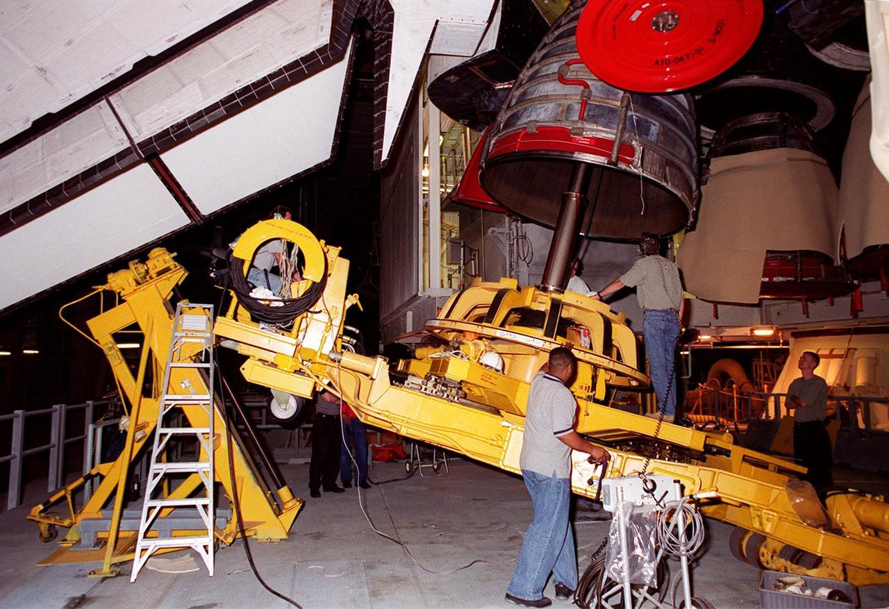 KENNEDY SPACE CENTER, FLA. -- Workers in the Vehicle Assembly Building maneuver equipment in place to remove Main Engine No. 1 from Space Shuttle Atlantis in the Vehicle Assembly Building. An inventory review concerning defective main engine fuel pump tip seals indicated that defective seals may be present on the fuel pump for the engine. The decision was made to replace the suspect engine with one originally slated for Discovery. The main engine nozzles, visible in the photo, are 7.8 feet across and 9.4 feet high. Space Shuttle Atlantis is scheduled to launch no earlier than April 17, 2000, on mission STS-101 to resupply the International Space Station for the arrival of the next pressurized module, the Russian-built Zvezda