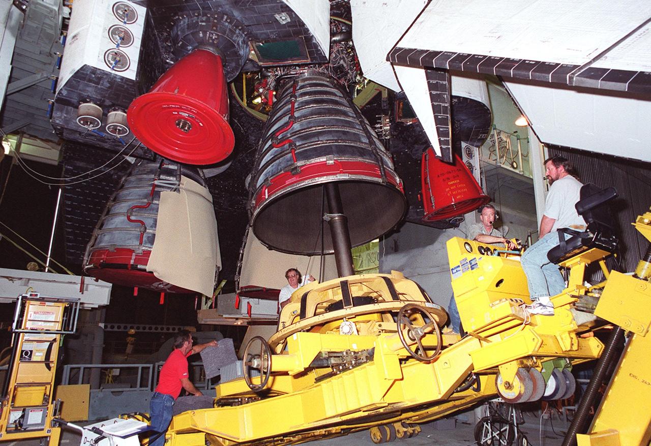 KENNEDY SPACE CENTER, FLA. -- Underneath the 26.3-foot vertical tail structure of Space Shuttle Atlantis (above right) in the Vehicle Assembly Building, workers place equipment to be used for the removal of Main Engine No. 1. An inventory review concerning defective main engine fuel pump tip seals indicated that defective seals may be present on the fuel pump for the engine. The decision was made to replace the suspect engine with one originally slated for Discovery. The main engine nozzles, visible in the photo, are 7.8 feet across and 9.4 feet high. Space Shuttle Atlantis is scheduled to launch no earlier than April 17, 2000, on mission STS-101 to resupply the International Space Station for the arrival of the next pressurized module, the Russian-built Zvezda