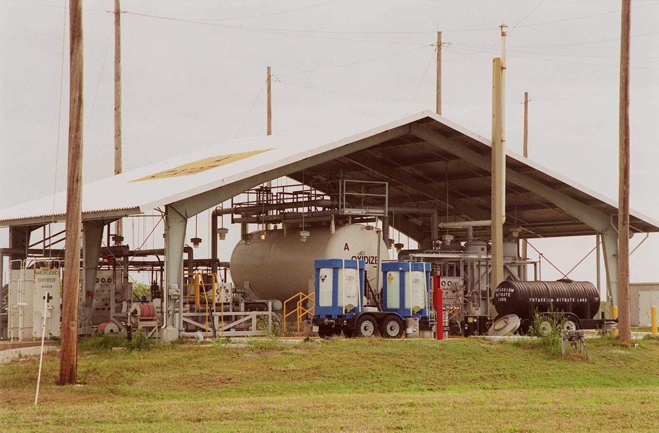 A recently installed fertilizer-producing system sits near Launch Pad 39A. Using a &quot;scrubber,&quot; the system captures nitrogen tetroxide vapor that develops as a by-product when it is transferred from ground storage tanks into the Shuttle storage tanks. Nitrogen tetroxide is used as the oxidizer for the hypergolic propellant in the Shuttle's on-orbit reaction control system. The scrubber then uses hydrogen peroxide to produce nitric acid, which, after adding potassium hydroxide, converts to potassium nitrate, a commercial fertilizer. Plans call for the resulting fertilizer to be used on the orange groves that KSC leases to outside companies