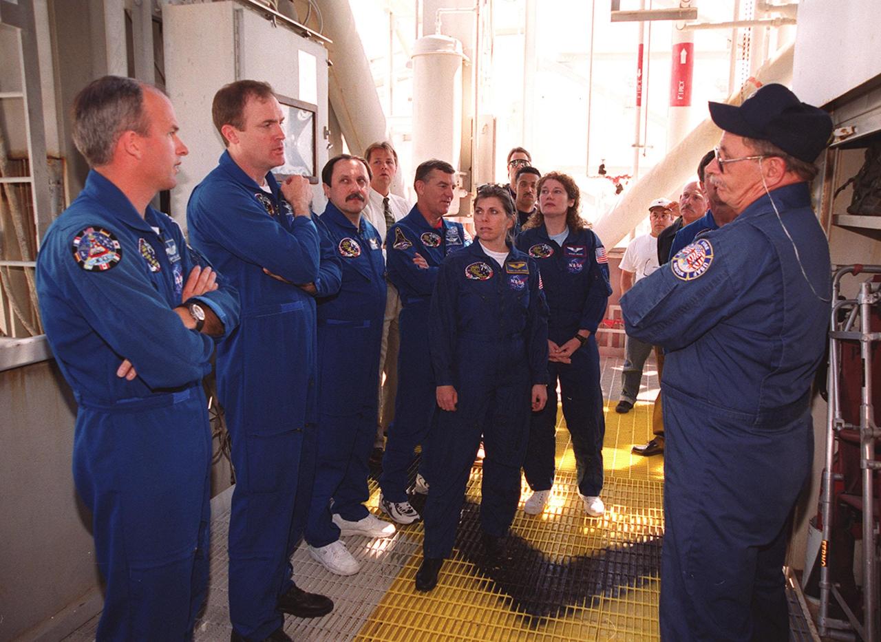 KENNEDY SPACE CENTER, Fla. -- At the 195-foot level of the Fixed Service Structure on Launch Pad 39A, the STS-101 crew take part in training during a Terminal Countdown Demonstration Test (TCDT). Activities during TCDT include emergency egress from the orbiter and a dress rehearsal for launch. Standing left to right are Pilot Scott Horowitz, Jeffrey Williams, Commander James Halsell, and Mission Specialists Yury Usachev, James Voss, Mary Ellen Weber, and Susan Helms. At right is trainer Capt. George Hoggard of the KSC/CCAS Fire Department. Not seen in the photo is Pilot Scott Horowitz. During their mission to the International Space Station, the STS-101 crew will be delivering logistics and supplies, plus preparing the Station for the arrival of the Zvezda Service Module, expected to be launched by Russia in July 2000. Also, the crew will conduct one space walk to perform maintenance on the Space Station. This will be the third assembly flight for the Space Station. STS-101 is scheduled to launch April 24 at 4:15 p.m. from Launch Pad 39A