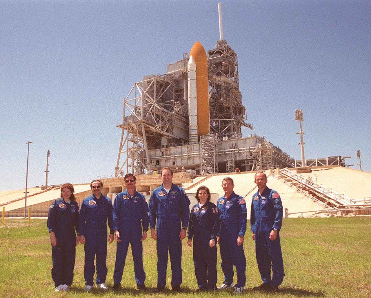KENNEDY SPACE CENTER, Fla. -- During a break in their Terminal Countdown Demonstration Test (TCDT), the STS-101 crew poses in front of Space Shuttle Atlantis at Launch Pad 39A. Standing, left to right, are Mission Specialists Susan J. Helms and Yury Usachev of Russia; Pilot Scott J. "Doc" Horowitz; Commander James D. Halsell Jr.; and Mission Specialists Mary Ellen Weber, James Voss and Jeffrey N. Williams. The TCDT includes emergency egress training and a simulated launch countdown. During their mission to the International Space Station, the STS-101 crew will be delivering logistics and supplies, plus preparing the Station for the arrival of the Zvezda Service Module, expected to be launched by Russia in July 2000. Also, the crew will conduct one space walk to perform maintenance on the Space Station. This will be the third assembly flight for the Space Station. STS-101 is scheduled to launch April 24 at 4:15 p.m. from Launch Pad 39A