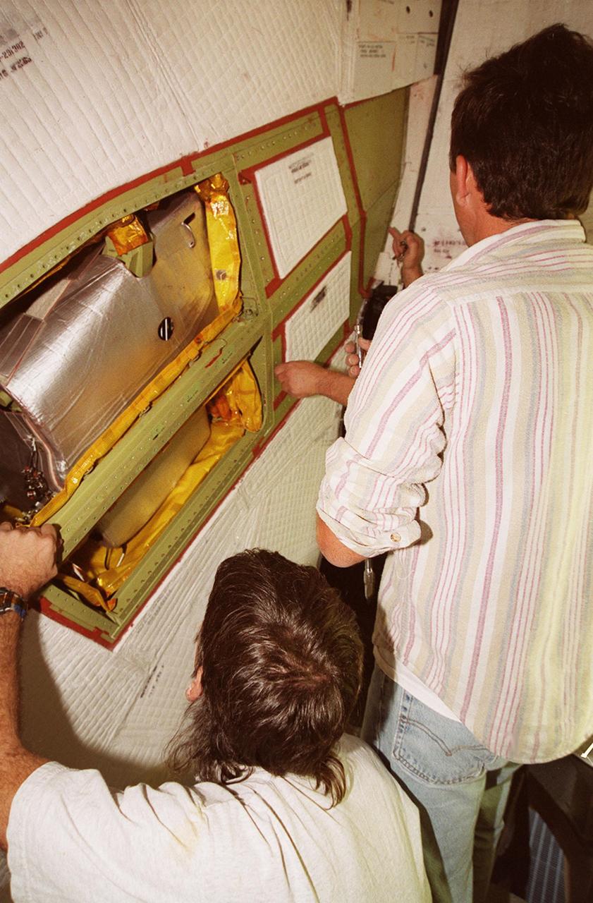 KENNEDY SPACE CENTER, FLA. -- United Space Alliance technicians (left to right) Tod Biddle, Bob Wright and Mark Noel (hidden) remove the coverings from a site near the tail of Space Shuttle Atlantis to reveal the power drive unit (PDU) inside. The PDU controls the rudder/speed brake on the orbiter. Shuttle managers decided to replace the faulty PDU, about the size of an office copy machine, at the launch pad. If successful, launch preparations will continue as planned, with liftoff targeted for April 24 at 4:15 p.m. on mission STS-101. The mission is the third assembly flight for the International Space Station, carrying logistics and supplies to the Space Station, plus the crew will be preparing the Station for the arrival of the Zvezda Service Module, expected to be launched by Russia in July 2000. The crew will conduct one space walk to perform maintenance on the Space Station