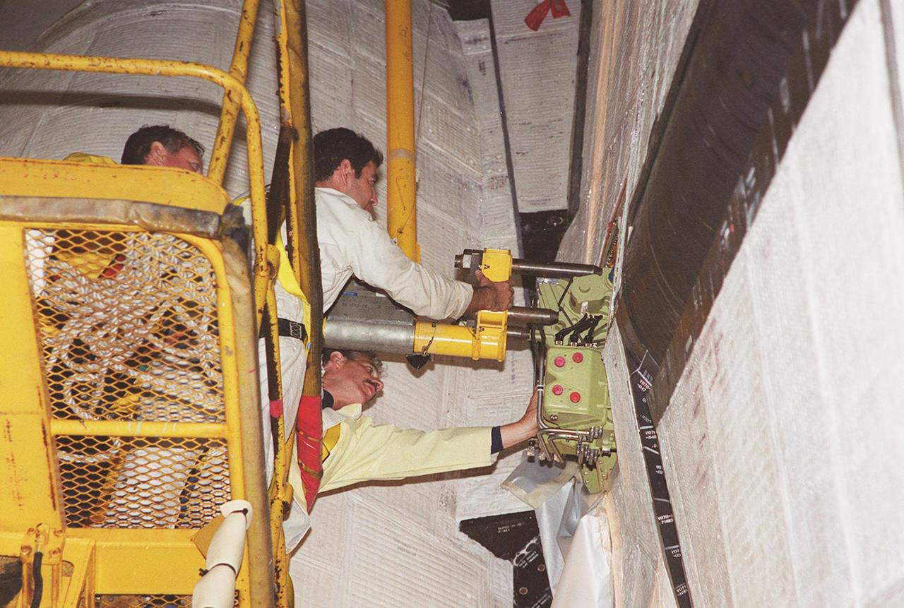KENNEDY SPACE CENTER, FLA. -- At Launch Pad 39A, workers move the replacement Power Drive Unit (PDU) into the body of Space Shuttle Atlantis. The PDU controls the rudder/speed brake on the orbiter. Atlantis is scheduled to lift off April 24 at 4:15 p.m. EDT on mission STS-101, the third flight to the International Space Station. The primary mission is to carry logistics and supplies to the Space Station, plus the crew will be preparing the Station for the arrival of the Zvezda Service Module, expected to be launched by Russia in July 2000