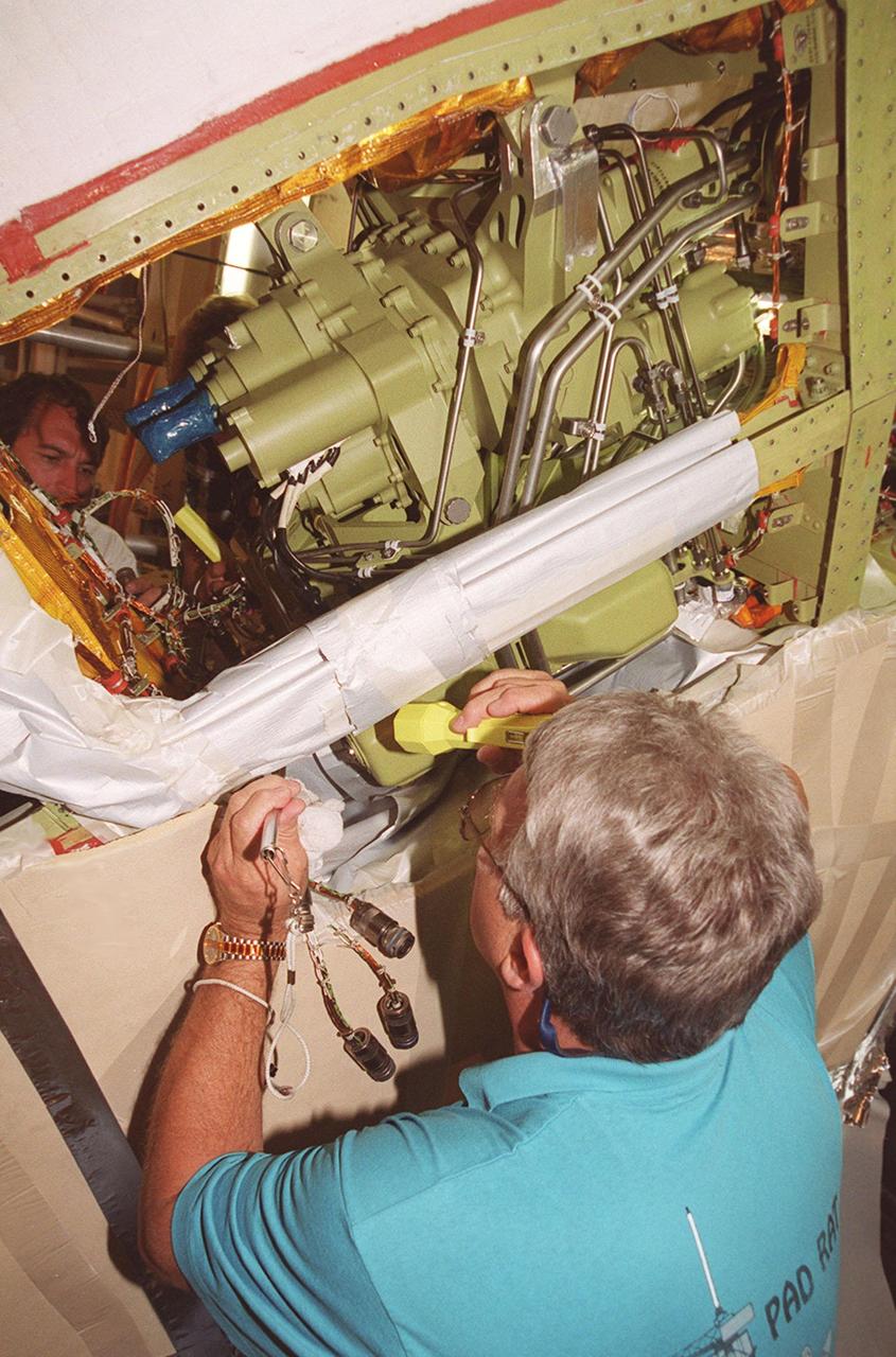 At Launch Pad 39A, Greg Lohning, who is with NASA, inspects the wiring on the newly installed Power Drive Unit (PDU) in Space Shuttle Atlantis. The PDU controls the rudder/speed brake on the orbiter. Atlantis is scheduled to lift off April 24 at 4:15 p.m. EDT on mission STS-101, the third flight to the International Space Station. The primary mission is to carry logistics and supplies to the Space Station, plus the crew will be preparing the Station for the arrival of the Zvezda Service Module, expected to be launched by Russia in July 2000