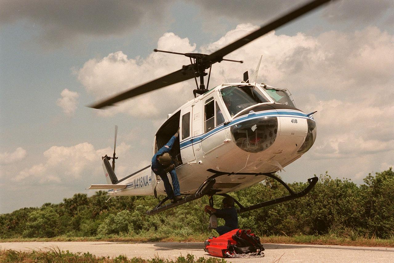KENNEDY SPACE CENTER, FLA. -- Workers attach a high-impact-resistant flexible plastic bucket to a NASA helicopter. Holding 324 gallons of water, it will be used for fire protection on property and buildings at Kennedy Space Center. Known as the "Bambi" bucket, it will also support the Fish and Wildlife Service for controlled burns plus any wild fires in the area.