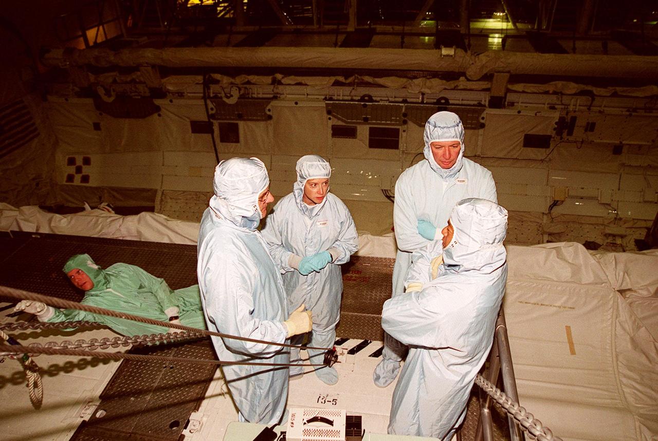 KENNEDY SPACE CENTER, FLA. -- Members of the STS-92 crew take a moment for discussion while checking out the payload bay of the orbiter Discovery in the Orbiter Processing Facility bay 1. Their mission, the fourth U.S. flight to the ISS, includes as payload the Integrated Truss Structure Z1, an early exterior framework to allow the first U.S. solar arrays on a future flight to be temporarily installed on Unity for early power; Ku-band communication to support early science capability and U.S. television; and PMA-3 to provide a Shuttle docking port for solar array installation on the sixth ISS flight and Lab installation on the seventh ISS flight. The crew comprises Mission Commander Brian Duffy, Pilot Pamela Melroy, and Mission Specialists Koichi Wakata, Leroy Chiao, Peter "Jeff" Wisoff, Michael Lopez-Alegria, and William McArthur. Launch of STS-92 is scheduled for Sept. 21, 2000. Wakata is with the National Space Development Agency of Japan