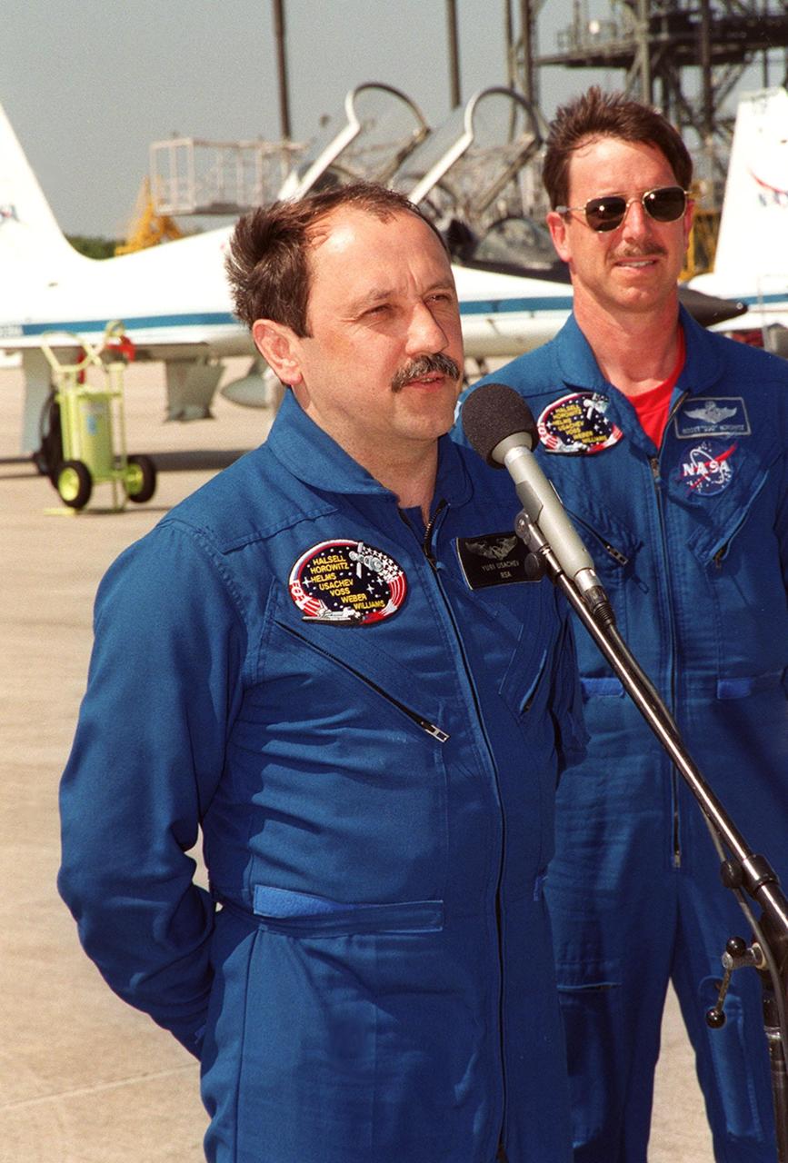 After arriving at the Shuttle Landing Facility for launch preparations, the STS-101 crew pauses to greet the media. At the microphone is Mission Specialist Yury Usachev of Russia. Behind him is Pilot Scott "Doc" Horowitz. Other crew members not shown are Commander James Halsell and Mission Specialists Mary Ellen Weber, James Voss, Jeffrey Williams and Susan Helms. The mission will take the crew to the International Space Station, delivering logistics and supplies, plus preparing the Station for the arrival of the Zvezda Service Module, expected to be launched by Russia in July 2000. Also, the crew will conduct one space walk to perform maintenance on the Space Station. This will be the third assembly flight for the Space Station. Launch is targeted for April 24 at about 4:15 p.m. EDT from Launch Pad 39A