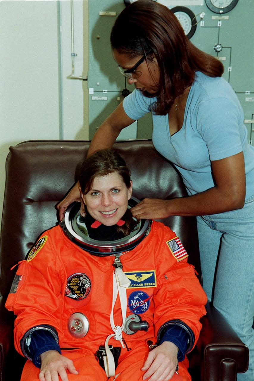 During pre-launch preparations in the Operations and Checkout Building, STS-101 Mission Specialist Mary Ellen Weber has her launch and entry suit checked by a technician. Mission STS-101 will take the crew to the International Space Station to deliver logistics and supplies, plus prepare the Station for the arrival of the Zvezda Service Module, expected to be launched by Russia in July 2000. The crew will conduct one space walk to perform maintenance on the Space Station as well. This will be the third assembly flight for the Space Station. Launch is targeted for April 24 at about 4:15 p.m. EDT from Launch Pad 39A