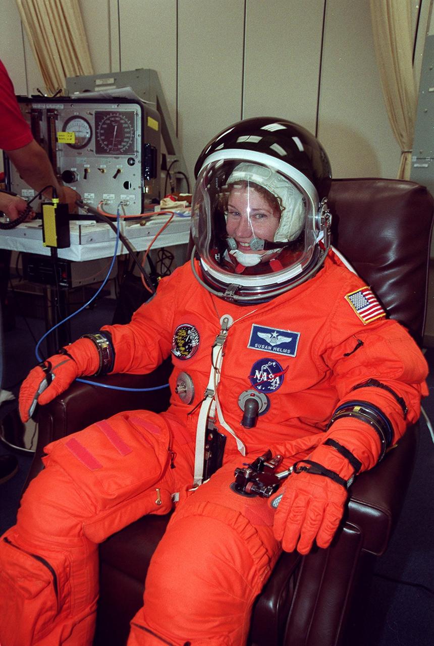 During pre-launch preparations in the Operations and Checkout Building, STS-101 Mission Specialist Susan Helms waits while her launch and entry suit is checked. Mission STS-101 will take the crew to the International Space Station to deliver logistics and supplies, plus prepare the Station for the arrival of the Zvezda Service Module, expected to be launched by Russia in July 2000. The crew will conduct one space walk to perform maintenance on the Space Station as well. This will be the third assembly flight for the Space Station. Launch is targeted for April 24 at about 4:15 p.m. EDT from Launch Pad 39A