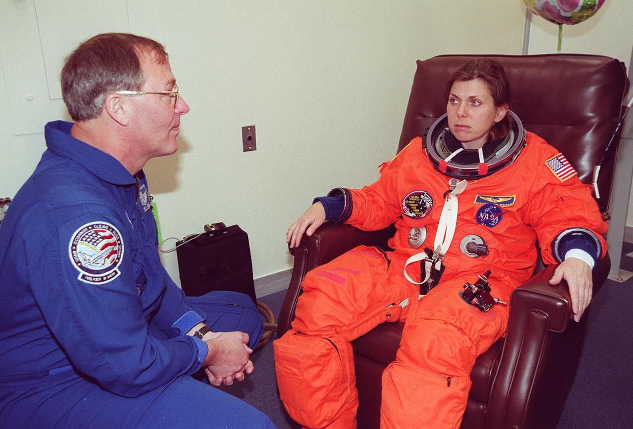 In the Operations and Checkout Building, STS-101 Mission Specialist Mary Ellen Weber talks with astronaut Jerry Ross while she waits to finish suiting up before heading to Launch Pad 39A and launch of Space Shuttle Atlantis. The mission will take the crew to the International Space Station to deliver logistics and supplies and to prepare the Station for the arrival of the Zvezda Service Module, expected to be launched by Russia in July 2000. Also, the crew will conduct one space walk. This will be the third assembly flight to the Space Station