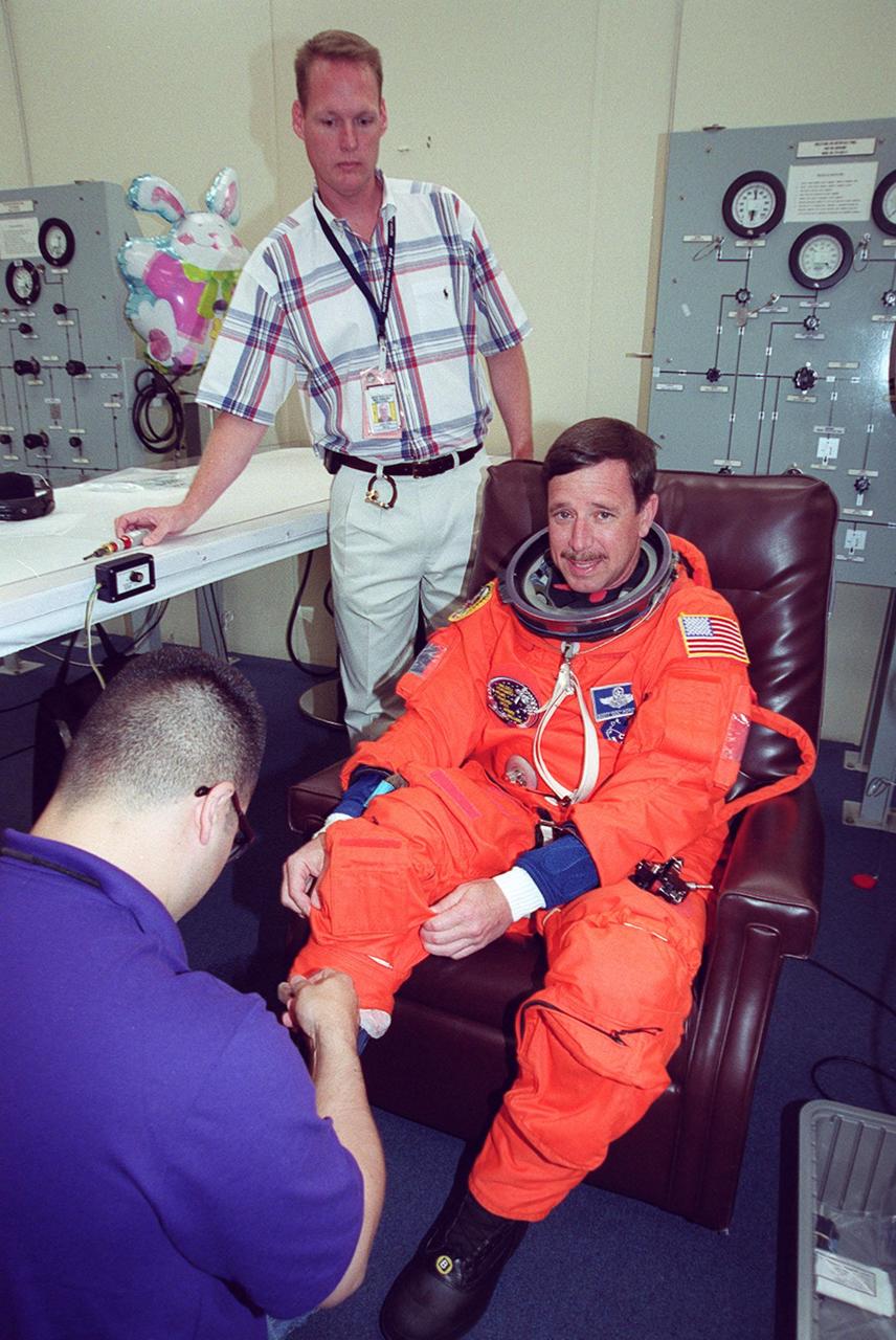 In the Operations and Checkout Building, STS-101 Pilot Scott J. Horowitz gets help suiting up before heading to Launch Pad 39A and launch of Space Shuttle Atlantis. The mission will take the crew to the International Space Station to deliver logistics and supplies and to prepare the Station for the arrival of the Zvezda Service Module, expected to be launched by Russia in July 2000. Also, the crew will conduct one space walk. This will be the third assembly flight to the Space Station