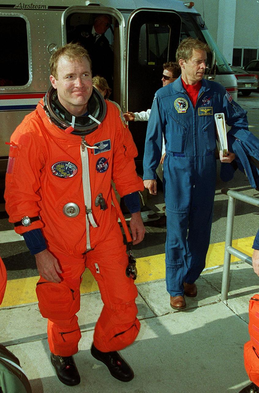 The STS-101 crew returns to the Operations and Checkout Building after the launch was scrubbed due to cross winds at the KSC Shuttle Landing Facility gusting above 20 knots. Flight rules require cross winds at the SLF to be no greater than 15 knots in case of a contingency Shuttle landing. Shown at left is Commander James D. Halsell Jr. At right is astronaut James Wetherbee, deputy director of the Johnson Space Center. Weather conditions will be reevaluated for another launch try on April 25. The mission will take the crew to the International Space Station to deliver logistics and supplies and to prepare the Station for the arrival of the Zvezda Service Module, expected to be launched by Russia in July 2000. Also, the crew will conduct one space walk. This will be the third assembly flight to the Space Station. The mission is expected to last about 10 days