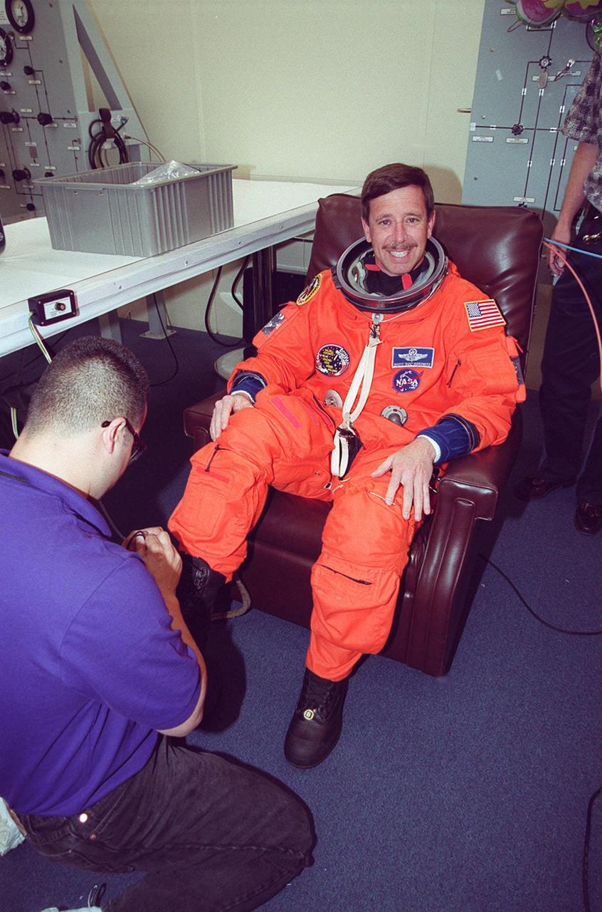In the Operations and Checkout Building, STS-101 Pilot Scott J. Horowitz smiles while he finishes suiting up before heading a second time to Launch Pad 39A for launch of Space Shuttle Atlantis. The previous day's launch attempt was scrubbed due to high cross winds at the Shuttle Landing Facility. The mission will take the crew to the International Space Station to deliver logistics and supplies and to prepare the Station for the arrival of the Zvezda Service Module, expected to be launched by Russia in July 2000. Also, the crew will conduct one space walk. This will be the third assembly flight to the Space Station. Liftoff is targeted for 3:52 p.m. EDT. The mission is expected to last about 10 days, with Atlantis landing at KSC Saturday, May 6, about 11:53 a.m. EDT
