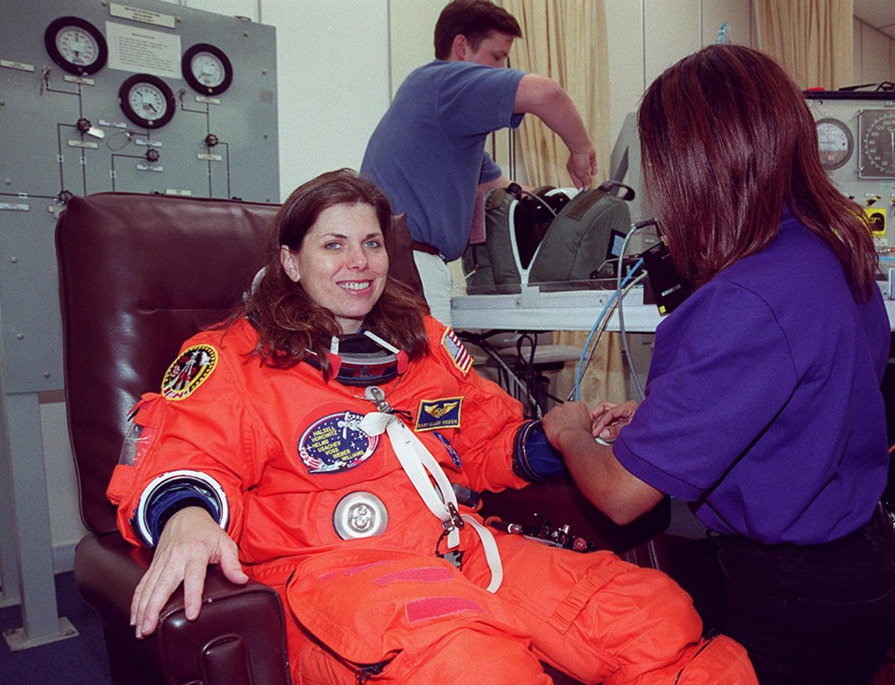 In the Operations and Checkout Building, STS-101 Mission Specialist Mary Ellen Weber is helped to suit up before heading for a second time to Launch Pad 39A and launch of Space Shuttle Atlantis. The previous day's launch attempt was scrubbed due to high cross winds at the Shuttle Landing Facility. The mission will take the crew to the International Space Station to deliver logistics and supplies and to prepare the Station for the arrival of the Zvezda Service Module, expected to be launched by Russia in July 2000. Also, the crew will conduct one space walk. This will be the third assembly flight to the Space Station. Liftoff is targeted for 3:52 p.m. EDT. The mission is expected to last about 10 days, with Atlantis landing at KSC Saturday, May 6, about 11:53 a.m. EDT