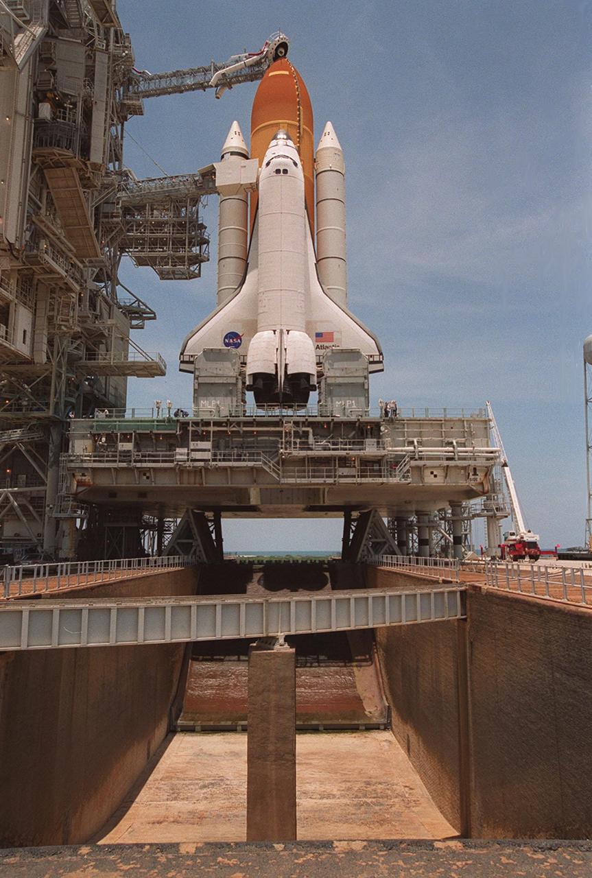 KENNEDY SPACE CENTER, Fla.  --  After rollback of the Rotating Service Structure, Space Shuttle Atlantis can be seen atop the mobile launcher platform (MLP) on Launch Pad 39A. Below the MLP is the flame trench, part of the flame deflector system that insulates pad structures from the intense heat of launch. Made of concrete and refractory brick, the trench is 490 feet long, 48 feet wide and 40 feet high. At the top of the orange external tank can be seen the Gaseous Oxygen Vent Hood, often called the "beanie cap." The hood helps vent gaseous oxygen vapors away from the Space Shuttle. The hood will be raised and retracted two and a half minutes before launch. Abutting the side of Atlantis is the orbiter access arm with the environmental chamber known as the White Room at the end. The White Room provides access to the crew compartment. This will be the third assembly flight to the International Space Station. Liftoff of Space Shuttle Atlantis for the 10-day STS-101 mission is scheduled for about 6:12 a.m. EDT from Launch Pad 39A. Landing is targeted for May 29 at 2:19 a.m. EDT. This is the 98th Shuttle flight and the 21st flight for Shuttle Atlantis