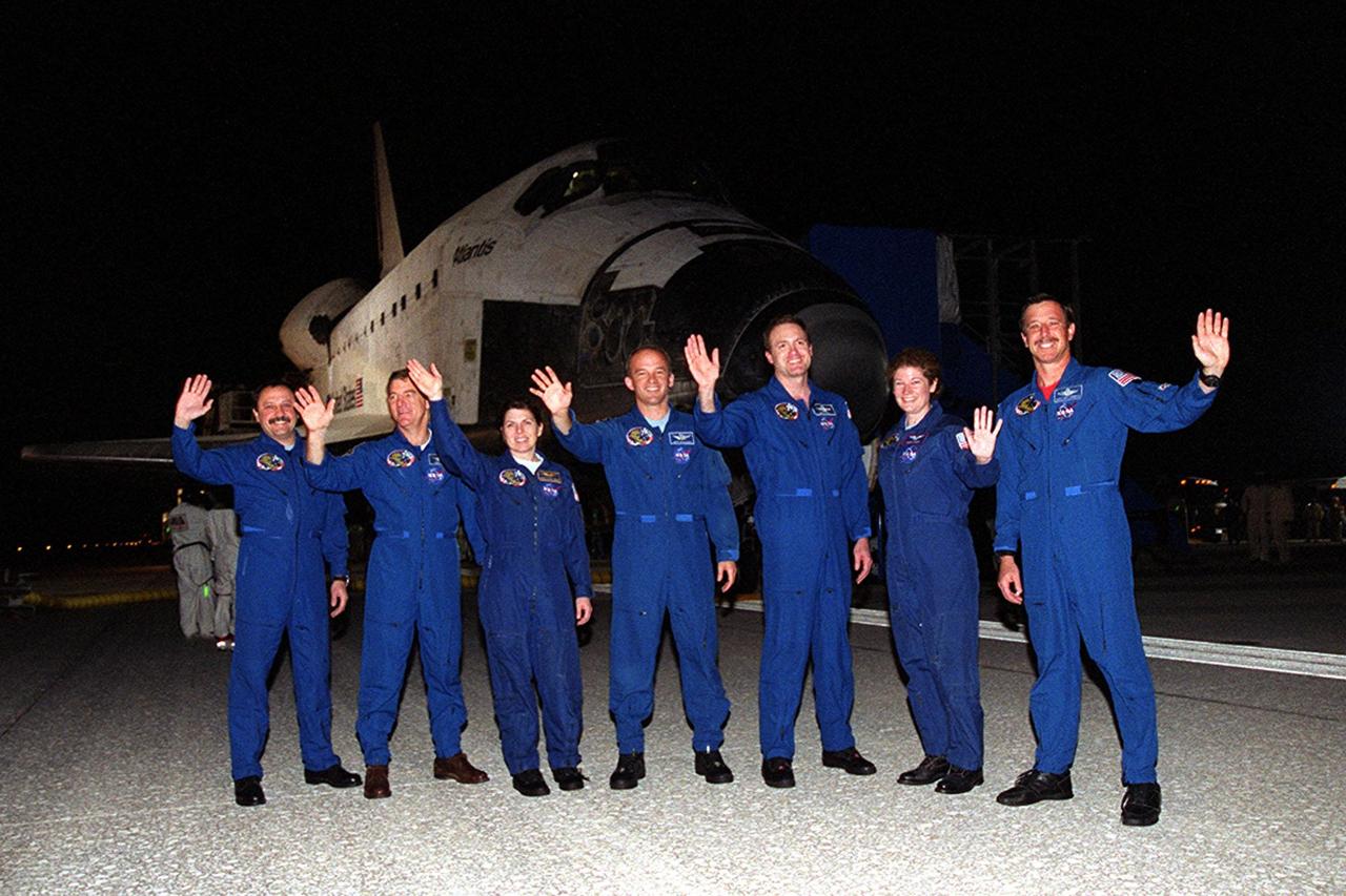 KENNEDY SPACE CENTER, FLA. -- Standing in front of Space Shuttle Atlantis on Runway 15 of the Shuttle Landing Facility, the STS-101 crew waves at the crowd gathered to welcome the astronauts home. From left are Mission specialists Yury Usachev of Russia, James S. Voss, Mary Ellen Weber, Jeffrey N. Williams; Commander James D. Halsell Jr.; Mission Specialist Susan J. Helms; and Pilot Scott “Doc” Horowitz. The crew returned from the third flight to the International Space Station, providing maintenance and carrying supplies for future missions. Main gear touchdown was at 2:20:17 a.m. EDT May 29 , landing on orbit 155 of the mission. Nose gear touchdown was at 2:20:30 a.m. EDT, and wheel stop at 2:21:19 a.m. EDT. This was the 98th flight in the Space Shuttle program and the 21st for Atlantis, also marking the 51st landing at KSC, the 22nd consecutive landing at KSC, the 14th nighttime landing in Shuttle history and the 29th in the last 30 Shuttle flights