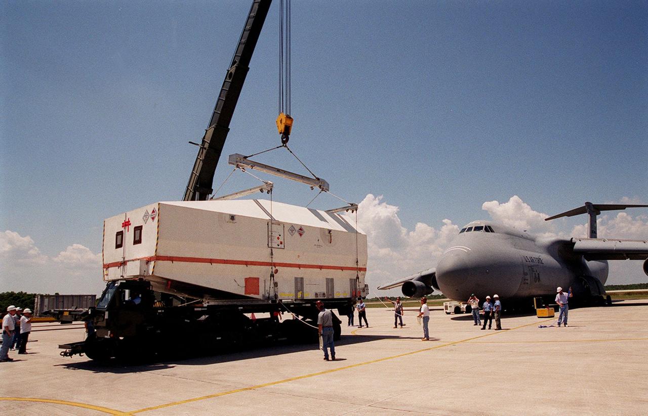 At the Shuttle Landing Facility, the crated Tracking and Data Relay Satellite (TDRS-H) is placed onto a transporter for its move to the Spacecraft Assembly and Encapsulation Facility (SAEF-2) for testing. The TDRS is one of three (labeled H, I and J) being built in the Hughes Space and Communications Company Integrated Satellite Factory in El Segundo, Calif. The latest TDRS uses an innovative springback antenna design. A pair of 15-foot-diameter, flexible mesh antenna reflectors fold up for launch, then spring back into their original cupped circular shape on orbit. The new satellites will augment the TDRS system’s existing Sand Ku-band frequencies by adding Ka-band capability. TDRS will serve as the sole means of continuous, high-data-rate communication with the space shuttle, with the International Space Station upon its completion, and with dozens of unmanned scientific satellites in low earth orbit. The TDRS is scheduled to be launched from CCAFS June 29 aboard an Atlas IIA/Centaur rocket