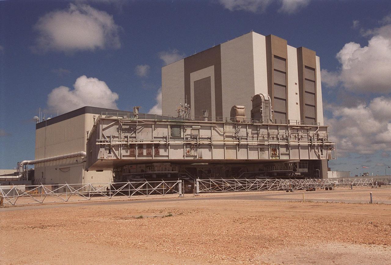 KENNEDY SPACE CENTER, FLA. -- A crawler-transporter with mobile launcher platform on top tests the buried portion of the Apollo-era crawlerway leading to the Vehicle Assembly Building (VAB) high bay 2 on the southwest side. The road was restored as part of KSC’s Safe Haven project. High bay 2 provides a third stacking area. The primary goal of the Safe Haven construction project was to strengthen readiness for hurricane season by expanding the VAB’s storage capacity. The new area, in high bay 2, will allow NASA to preassemble stacks and still have room in the VAB to pull a Shuttle back from the pad if severe weather threatens. Potential rollouts of the Space Shuttle to the launch pad from high bay 2 will involve making a turn around the north side of the VAB in contrast to the straight rollouts from high bays 1 and 3, on the east side of the VAB facing the launch pads
