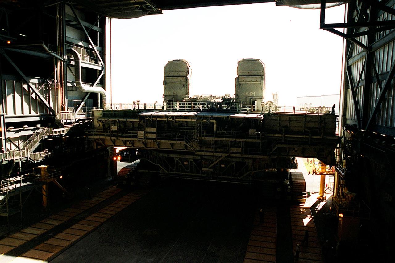 KENNEDY SPACE CENTER, FLA. -- From inside the VAB high bay 2, a mobile launcher platform atop a crawler transporter is viewed as it rolls through the doorway using the recently restored crawlerway. As part of the Safe Haven project, a once-buried portion of the crawlerway was restored to enable rollout of a Shuttle from high bay 2. The primary goal of the Safe Haven construction project was to strengthen readiness for hurricane season by expanding the VAB’s storage capacity. The new area, in high bay 2, will allow NASA to preassemble stacks and still have room in the VAB to pull a Shuttle back from the pad if severe weather threatens. Potential rollouts of the Space Shuttle to the launch pad from high bay 2 will involve making a turn around the north side of the VAB in contrast to the straight rollouts from high bays 1 and 3, on the east side of the VAB facing the launch pads