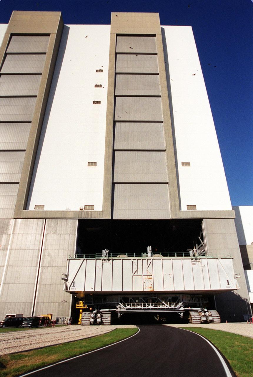 KENNEDY SPACE CENTER, FLA. -- A mobile launcher platform atop a crawler-transporter, heads through the open door of the Vehicle Assembly Building high bay 2. As part of the Safe Haven project, a once-buried portion of the crawlerway was restored to enable rollout of a Shuttle from this third stacking area. The primary goal of the Safe Haven construction project was to strengthen readiness for hurricane season by expanding the VAB’s storage capacity. The new area, in high bay 2, will allow NASA to preassemble stacks and still have room in the VAB to pull a Shuttle back from the pad if severe weather threatens. Potential rollouts of the Space Shuttle to the launch pad from high bay 2 will involve making a turn around the north side of the VAB in contrast to the straight rollouts from high bays 1 and 3, on the east side of the VAB facing the launch pads