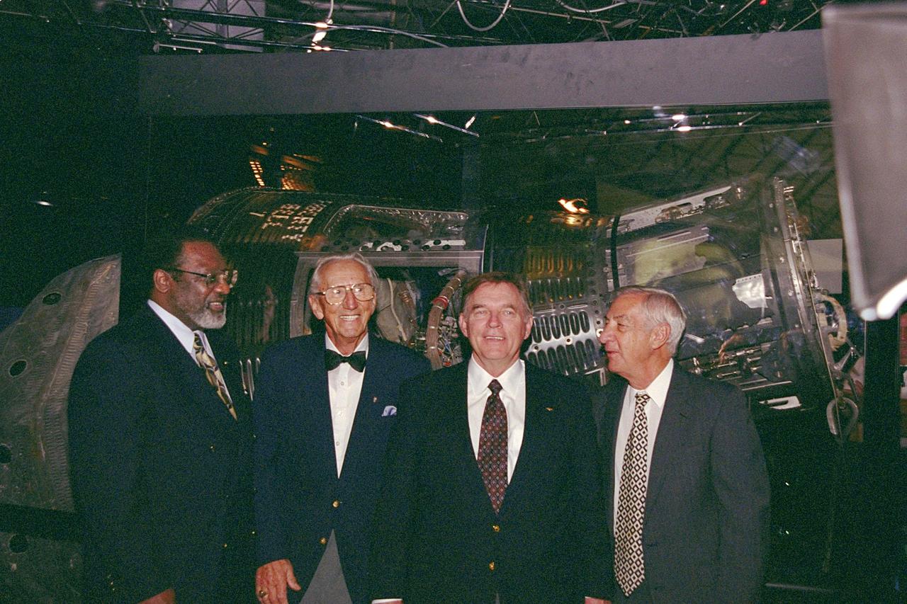 The Discovery Channel’s Liberty Bell 7 Space Capsule Exhibit, which opens to the public at the KSC Visitor Complex on Saturday, June 17, had a preview for the press today. Liberty Bell 7 launched U.S. Air Force Captain Virgil &quot;Gus&quot; Grissom July 21, 1961, on a mission that lasted 15 minutes and 37 seconds before sinking. The capsule lay undetected for nearly four decades before a Discovery Channel expedition located it and recovered it. Standing in front of the restored Liberty Bell 7 capsule are (left to right) KSC’s Deputy Director Jim Jennings; Gunther Wendt, who worked on the Liberty Bell 7 before its launch; Jim Lewis, who piloted the Hunt Club 1 helicopter that rescued Gus Grissom; and Larry Grissom, brother of Gus Grissom. The space capsule, now restored and preserved, is part of an interactive exhibit touring science centers and museums in 12 cities throughout the United States until 2003. The exhibit also includes hands-on elements such as a capsule simulator, a centrifuge, and ROV pilot