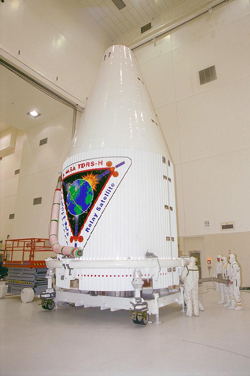 The Tracking and Data Relay Satellite (TDRS-H) sits fully encapsulated inside the fairing. Next, it will be transported to Launch Pad 36A, Cape Canaveral Air Force Station for launch scheduled June 29 aboard an Atlas IIA/Centaur rocket. One of three satellites (labeled H, I and J) being built in the Hughes Space and Communications Company Integrated Satellite Factory in El Segundo, Calif., the latest TDRS uses an innovative springback antenna design. A pair of 15-foot-diameter, flexible mesh antenna reflectors fold up for launch, then spring back into their original cupped circular shape on orbit. The new satellites will augment the TDRS system’s existing Sand Ku-band frequencies by adding Ka-band capability. TDRS will serve as the sole means of continuous, high-data-rate communication with the space shuttle, with the International Space Station upon its completion, and with dozens of unmanned scientific satellites in low earth orbit
