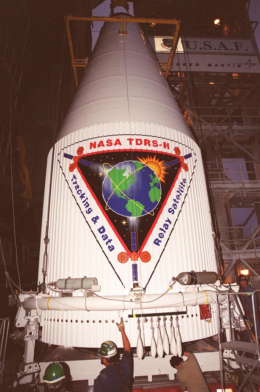 An overhead crane is positioned on the nose fairing covering the Tracking and Data Relay Satellite (TDRS-H) in order to lift it up the tower at Launch Pad 36A, Cape Canaveral Air Force Station. It will be mated with the Atlas IIA/Centaur rocket, which is already stacked, for launch on June 29. The satellite will augment the TDRS system’s existing Sand Ku-band frequencies by adding Ka-band capability. TDRS will serve as the sole means of continuous, high-data-rate communication with the Space Shuttle, with the International Space Station upon its completion, and with dozens of unmanned scientific satellites in low earth orbit