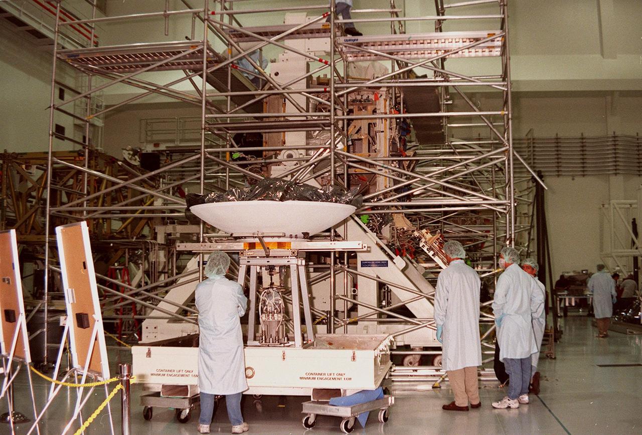 Workers in the Space Shuttle Processing Facility (SSPF) are getting ready to prepare the high-gain antenna beside them on the floor for installation on the Integrated Truss Structure (ITS) Z1, just beyond the scaffolding. The Z1 is an early exterior framework for the International Space Station to allow the first U.S. solar arrays, on mission STS-97, flight 4A, to be temporarily installed on Unity for early power. The Z1 is a payload scheduled on mission STS-92, the fifth flight to the Space Station, in the fall