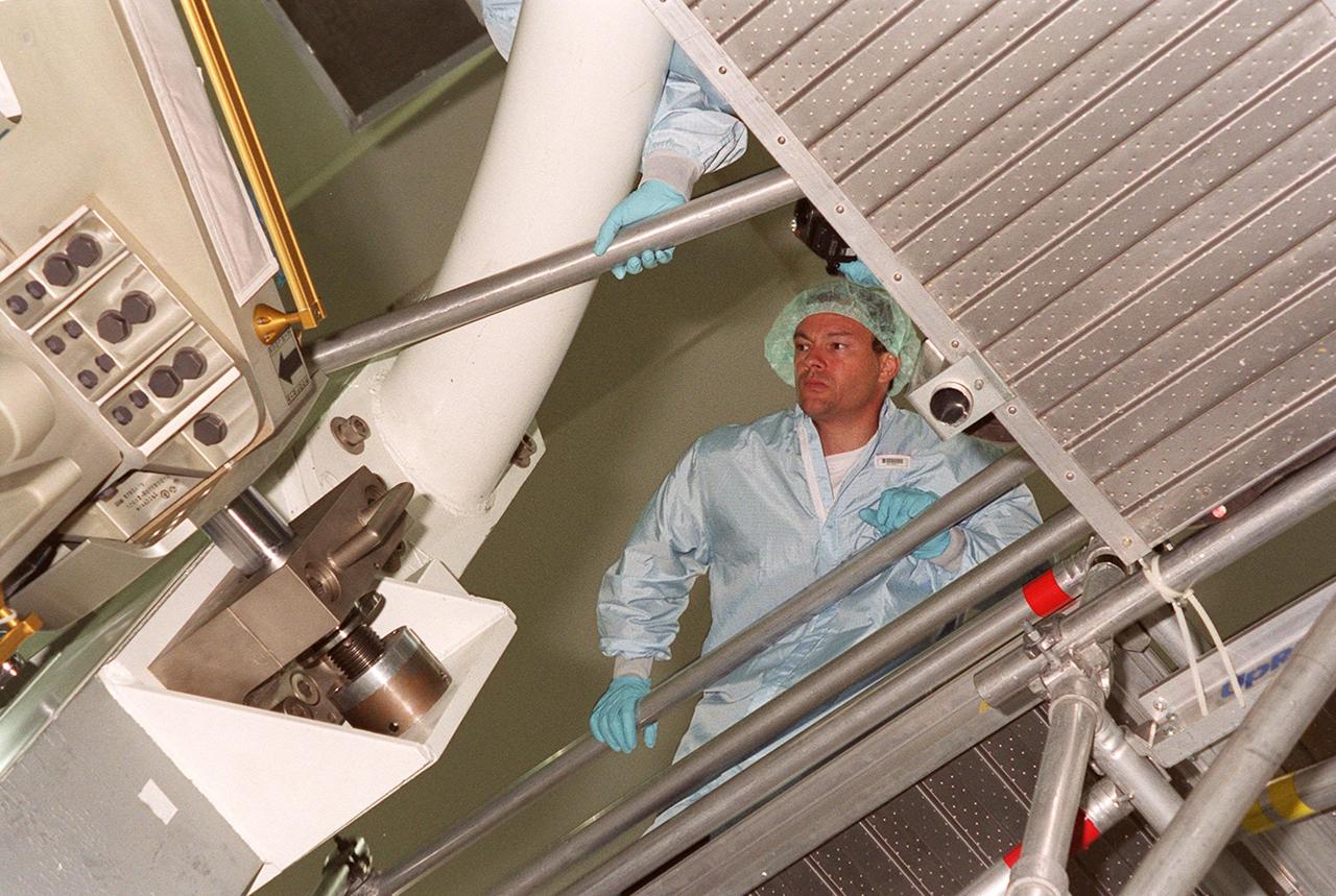 On the scaffolding in the Space Shuttle Processing Facility (SSPF), STS-92 Mission Specialist Michael Lopez-Alegria leans over to get a better look at the Integrated Truss Structure (ITS) Z1 below. The Z1 is a payload scheduled on mission STS-92, the fifth flight to the Space Station, in the fall. The Z1 is an early exterior framework for the International Space Station, and will allow the first U.S. solar arrays, on mission STS-97, flight 4A, to be temporarily installed on Unity for early power