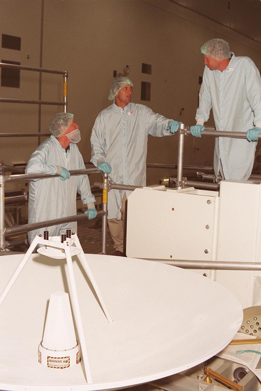 In the Space Shuttle Processing Facility, workers confer about the high-gain antenna in front of them that will be attached to the Integrated Truss Structure (ITS) Z1. The Z1, part of the payload on mission STS-92 (flight 3A) to be launched in mid-fall, is an early exterior framework for the International Space Station. It will allow the first U.S. solar arrays, on mission STS-97 (flight 4A), to be temporarily installed on Unity for early power