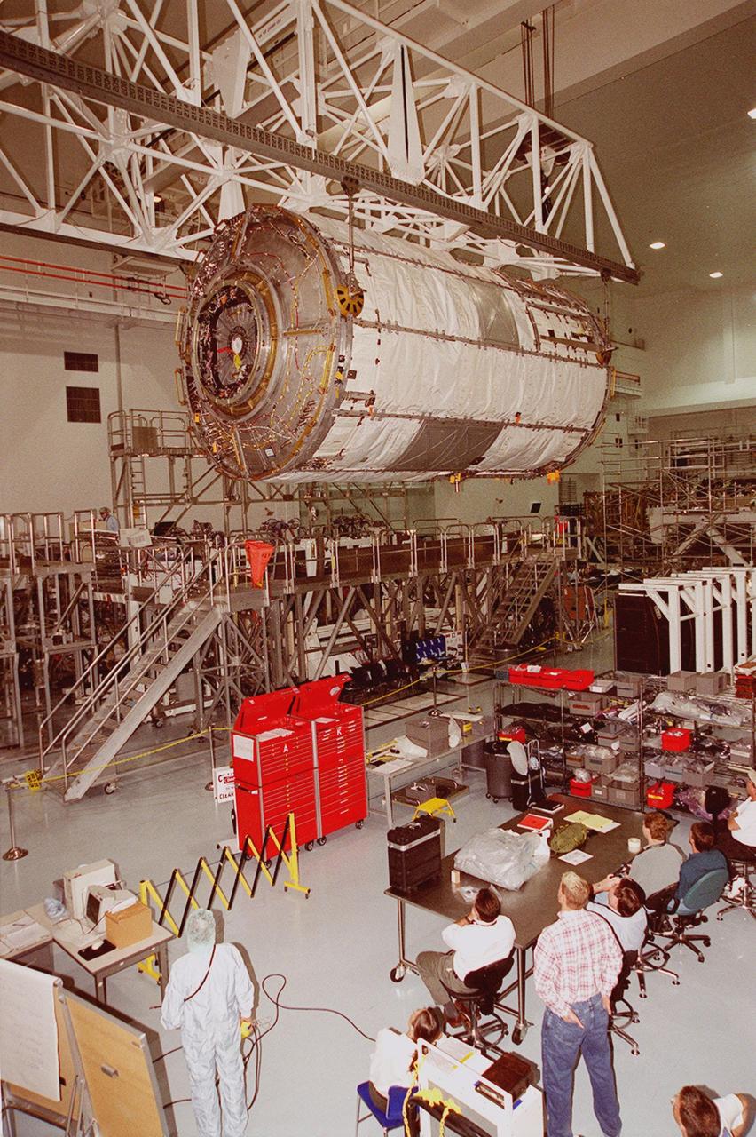 KENNEDY SPACE CENTER, FLA. -- Workers in the Space Station Processing Facility watch as the U.S. Lab Destiny, lifted by an overhead crane, glides through the air to a weigh stand. A component of the International Space Station, Destiny is scheduled to fly on mission STS-98 in early 2001. During the mission, the crew will install the Lab during a series of three space walks. The STS-98 mission will provide the station with science research facilities and expand its power, life support and control capabilities. The U.S. Lab module continues a long tradition of microgravity materials research, first conducted by Skylab and later Shuttle and Spacelab missions. Destiny is expected to be a major feature in future research, providing facilities for biotechnology, fluid physics, combustion, and life sciences research