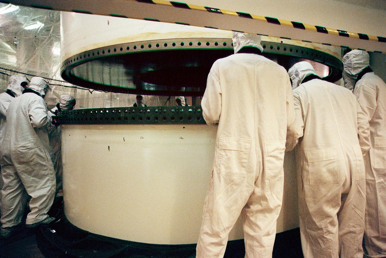 In the Vehicle Assembly Building, workers prepare to mate two segments of a solid rocket booster (SRB). The SRB is part of the stack for the STS-92 mission, scheduled for launch Oct. 5 from Launch Pad 39A