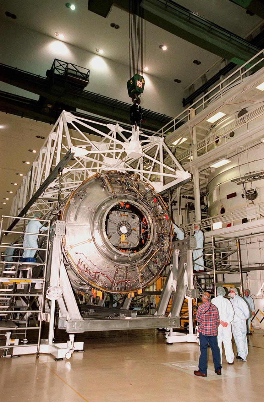 KENNEDY SPACE CENTER, FLA. -- In the Operations and Checkout Building, workers check the U.S. Lab, named Destiny, as it settles into the rotation and handling fixture in preparation for testing in the altitude chamber. Destiny is scheduled to fly on mission STS-98 in early 2001. During the mission, the crew will install the Lab in the Space Station during a series of three space walks. The STS-98 mission will provide the Station with science research facilities and expand its power, life support and control capabilities. The U.S. Lab module continues a long tradition of microgravity materials research, first conducted by Skylab and later Shuttle and Spacelab missions. Destiny is expected to be a major feature in future research, providing facilities for biotechnology, fluid physics, combustion, and life sciences research