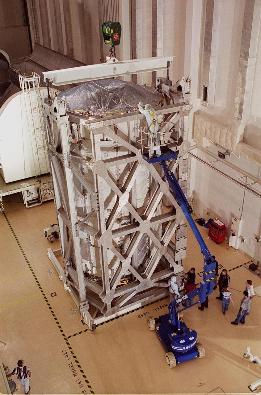 KENNEDY SPACE CENTER, FLA. -- A worker checks the cable fittings on the U.S. Lab, a component of the International Space Station, before it is lifted and placed inside the vacuum chamber in the Operations and Checkout Building. The 32,000-pound scientific research lab, named Destiny, is the first Space Station element to spend seven days in the renovated vacuum chamber for a leak test. Destiny is scheduled to be launched on Shuttle mission STS-98, the 5A assembly mission, targeted for Jan. 18, 2001. During the mission, the crew will install the Lab in the Space Station during a series of three space walks. The STS-98 mission will provide the Station with science research facilities and expand its power, life support and control capabilities. The U.S. Lab module continues a long tradition of microgravity materials research, first conducted by Skylab and later Shuttle and Spacelab missions. Destiny is expected to be a major feature in future research, providing facilities for biotechnology, fluid physics, combustion, and life sciences research