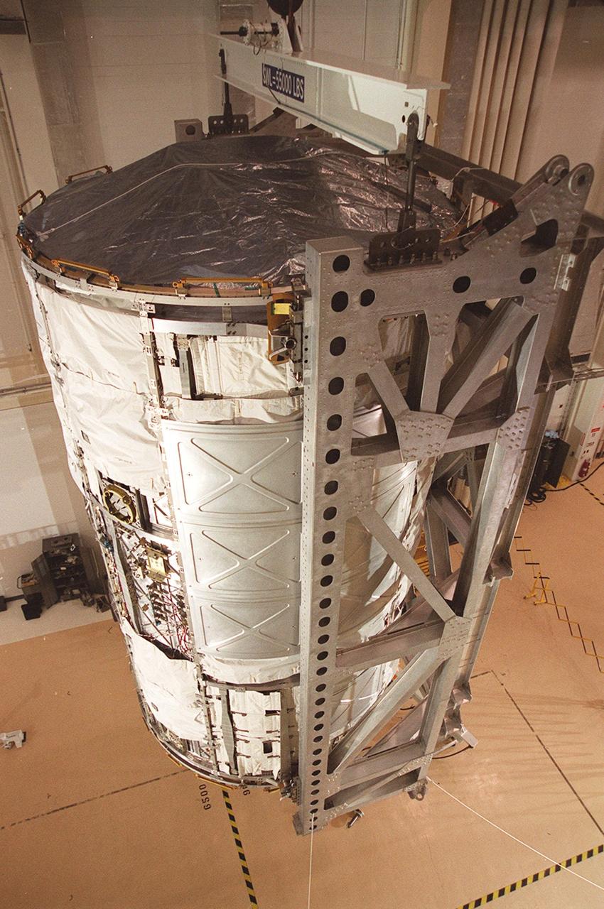 KENNEDY SPACE CENTER, FLA. -- The U.S. Lab, a component of the International Space Station, is lifted off the floor of the Operations and Checkout Building in order to be placed inside the vacuum chamber in the building. The 32,000-pound scientific research lab, named Destiny, is the first Space Station element to spend seven days in the renovated vacuum chamber for a leak test. Destiny is scheduled to be launched on Shuttle mission STS-98, the 5A assembly mission, targeted for Jan. 18, 2001. During the mission, the crew will install the Lab in the Space Station during a series of three space walks. The STS-98 mission will provide the Station with science research facilities and expand its power, life support and control capabilities. The U.S. Lab module continues a long tradition of microgravity materials research, first conducted by Skylab and later Shuttle and Spacelab missions. Destiny is expected to be a major feature in future research, providing facilities for biotechnology, fluid physics, combustion, and life sciences research
