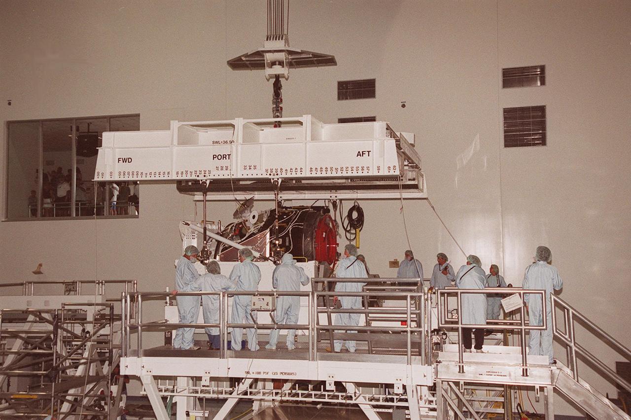 Workers in the Space Station Processing Facility gather around the Pressurized Mating Adapter -3 (PMA-3) as an overhead crane is set to lift and move it. The PMA-3, a component of the International Space Station, is being transported to the Orbiter Processing Facility. PMA-3 is part of the payload on Space Shuttle mission STS-92, scheduled to launch Oct. 5. The mission will be the fifth flight to the Space Station, and the 100th Shuttle flight overall. PMA-3 provides shuttle docking port for solar array installation on flight 4A (mission STS-97 scheduled for Nov. 30), and Lab installation on flight 5A (mission STS-98, scheduled for Jan. 18, 2001)