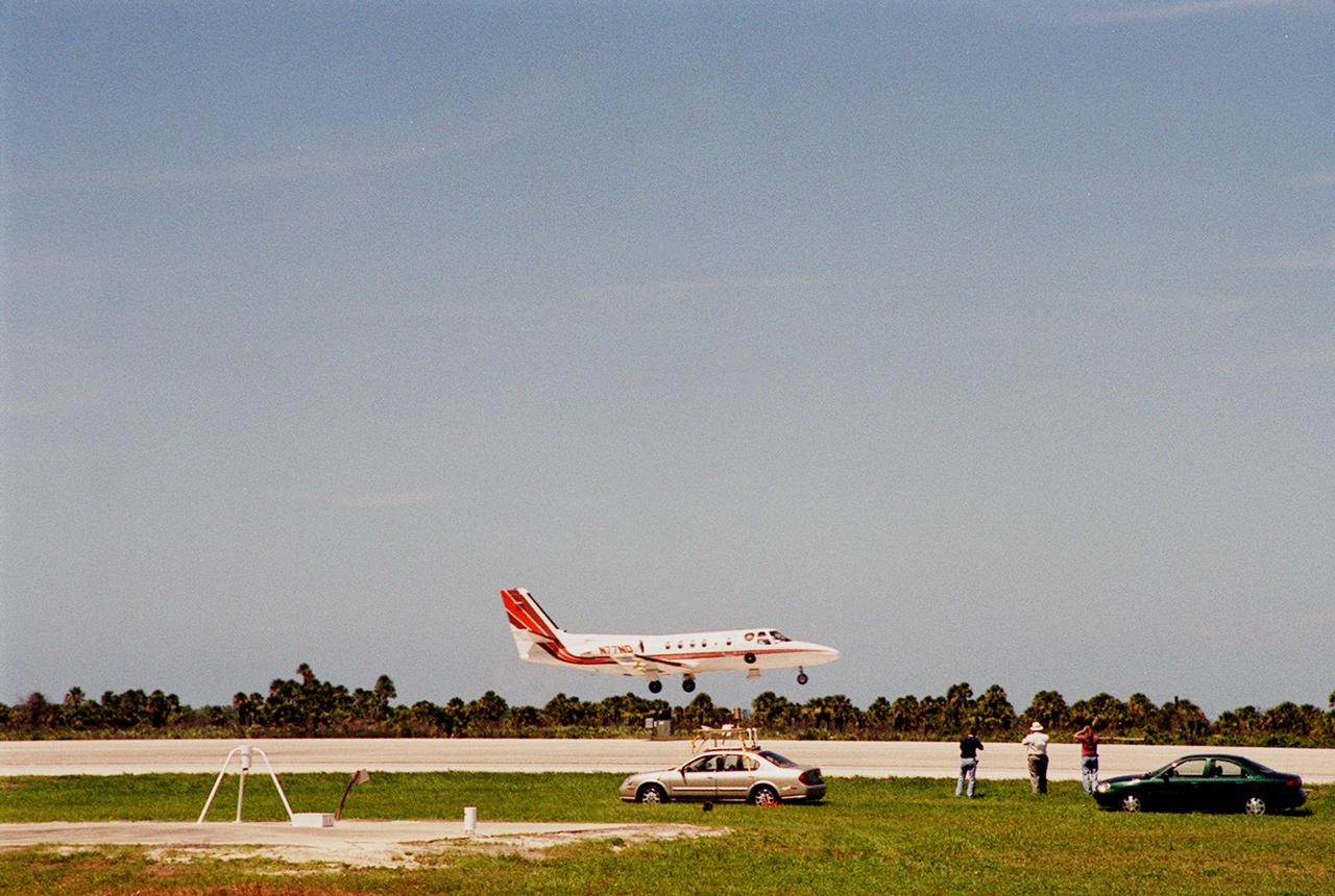 KENNEDY SPACE CENTER, FLA. -- At KSC's Shuttle Landing Facility, a specially equipped Cessna Citation aircraft flies over the runway to calibrate the Cesna's field mills with field mills on the ground (on the tripod at left) and on the car parked nearby (at center). Field mills measure electric fields. The aircraft is also equipped with cloud physics probes that measure the size, shape and number of ice and water particles in clouds. The plane is being flown into anvil clouds in the KSC area as part of a study to review and possibly modify lightning launch commit criteria. The weather study could lead to improved lightning avoidance rules and fewer launch scrubs for the Space Shuttle and other launch vehicles on the Eastern and Western ranges.