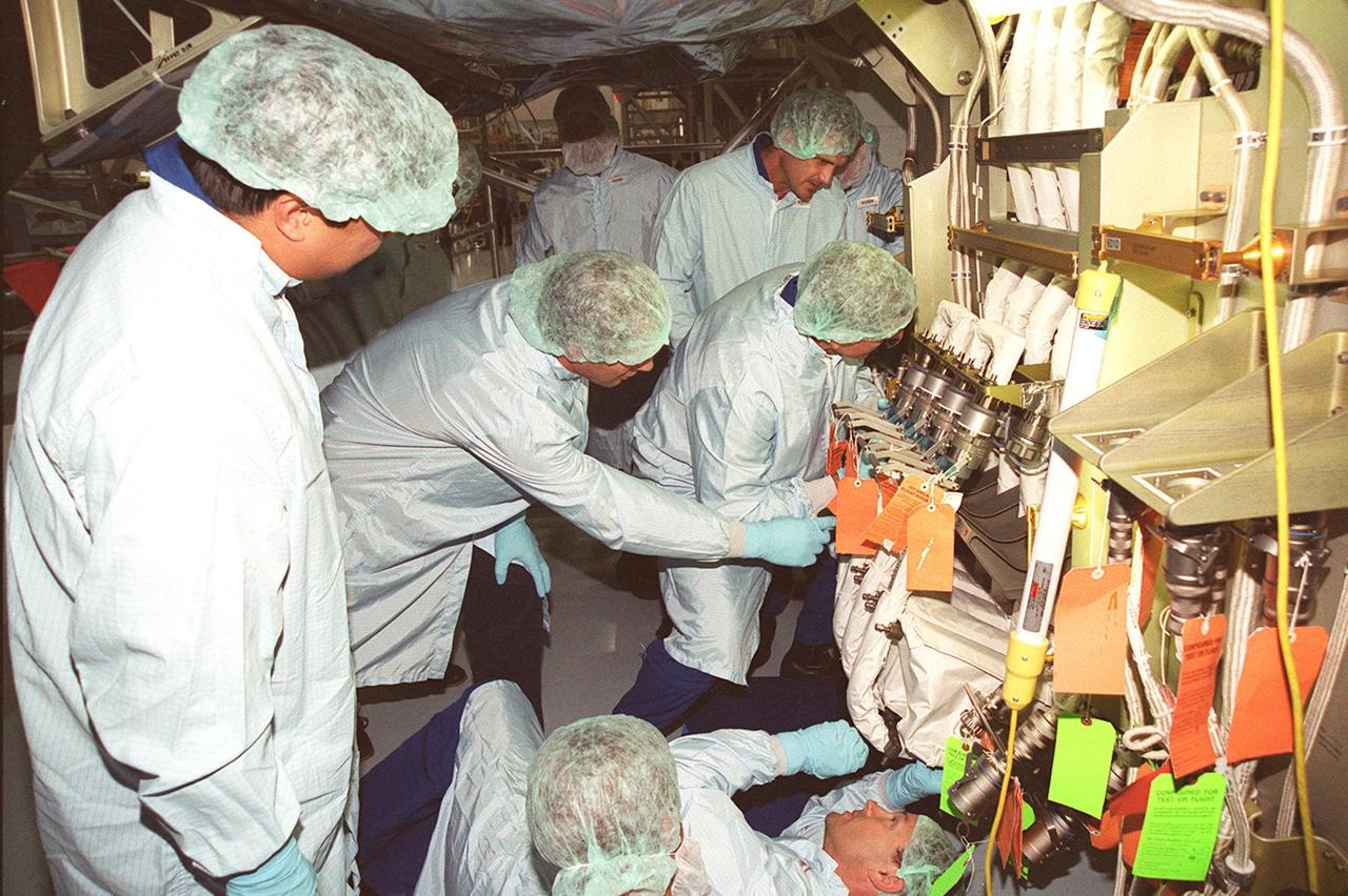 As part of Crew Equipment Interface Test (CEIT) activities, members of the STS-92 crew check out equipment they will be using on the mission to the International Space Station. At left is Mission Specialist Leroy Chiao, looking at part of the Integrated Truss Structure Z1, a component of the Station and payload on STS-92. Others seen in the photo are Mission Specialists Michael Lopez-Alegria (on his back, lower right); Jeff Wisoff (standing in back); and Bill McArthur (bending closer to the Z1 truss). Also taking part in the CIET are Commander Brian Duffy, Pilot Pam Melroy, and Mission Specialist Koichi Wakata. STS-92 is scheduled to launch Oct. 5 from launch Pad 39A