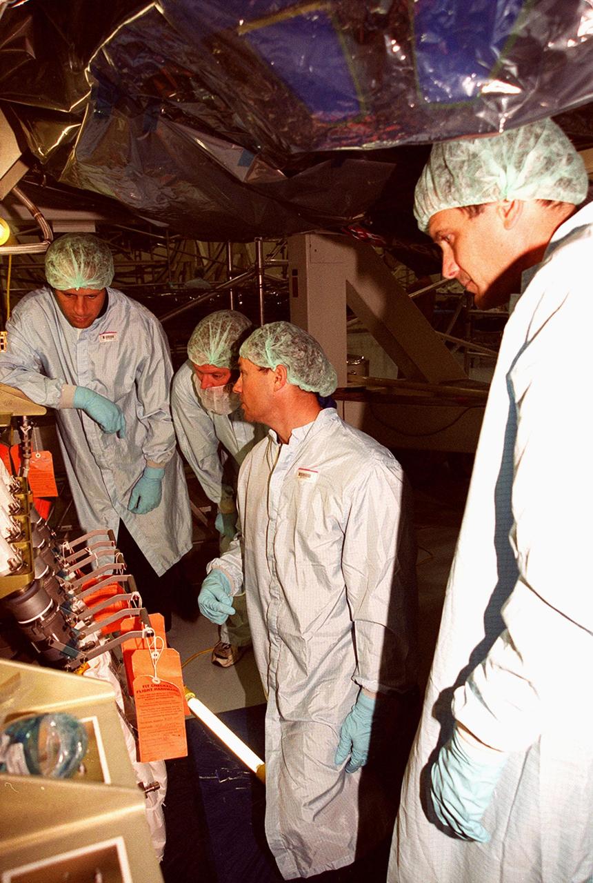 As part of Crew Equipment Interface Test (CEIT) activities, members of the STS-92 crew check out equipment they will be using on the mission to the International Space Station. Mission Specialists Michael Lopez-Alegria (center) and Jeff Wisoff (right) talk with Boeing technicians about the Integrated Truss Structure Z1, a component of the Station and payload on STS-92, in front of them. The Z1 truss is an early exterior framework to allow the first U.S. solar arrays on a future flight to be temporarily installed on Unity for early power. STS-92 is scheduled to launch Oct. 5 from launch Pad 39A