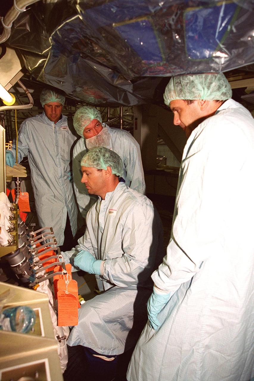 STS-92 Mission Specialists Michael Lopez-Alegria (center) and Jeff Wisoff (right) check out the Integrated Truss Structure Z1, a component of the International Space Station and payload on their mission. They and other crew members are taking part in Crew Equipment Interface Test (CEIT) activities while at KSC. The Z1 truss is an early exterior framework to allow the first U.S. solar arrays on a future flight to be temporarily installed on Unity for early power. STS-92 is scheduled to launch Oct. 5 from launch Pad 39A