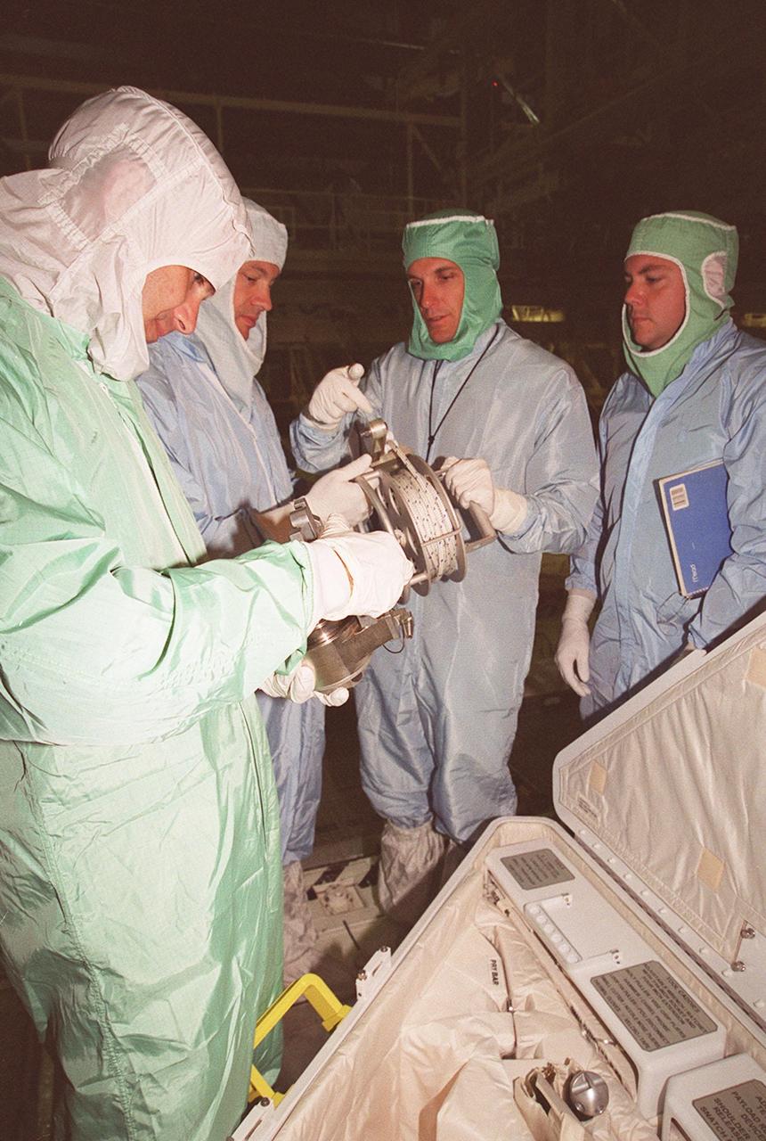 As part of Crew Equipment Interface Test activities, STS-92 Mission Specialists Jeff Wisoff (left) and Michael Lopez-Alegria (second from left) check equipment on orbiter Discovery that they will be using on their mission. At right are Boeing workers. Discovery is in the Orbiter Processing Facility bay 1. Other crew members taking part in the CEIT are Commander Brian Duffy, Pilot Pam Melroy, and Mission Specialists Koichi Wakata, Leroy Chiao, Jeff Wisoff, Michael Lopez-Alegria, and Bill McArthur. STS-92 is scheduled to launch Oct. 5 from Launch Pad 39A on the fifth flight to the International Space Station. Discovery will carry the Integrated Truss Structure (ITS) Z1, Pressurized Mating Adapter 3, Ku-band Communications System, and Control Moment Gyros (CMGs)