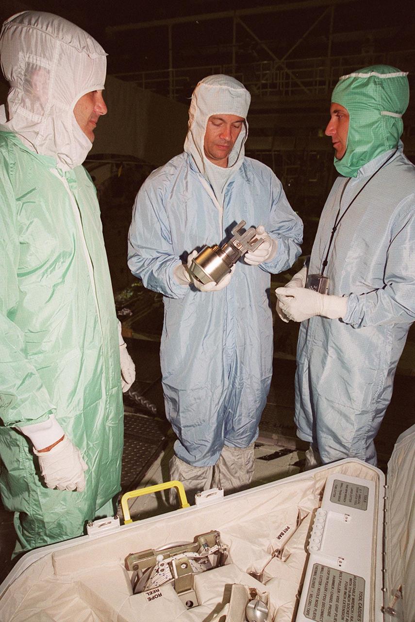 As part of Crew Equipment Interface Test (CEIT) activities, STS-92 Mission Specialists Jeff Wisoff (left) and Michael Lopez-Alegria (center) check equipment on the orbiter Discovery that they will be using on their mission. At right is a Boeing worker. Discovery is in the Orbiter Processing Facility bay 1. Other crew members taking part in the CEIT are Commander Brian Duffy, Pilot Pam Melroy, and Mission Specialists Koichi Wakata, Leroy Chiao and Bill McArthur. STS-92 is scheduled to launch Oct. 5 from Launch Pad 39A on the fifth flight to the International Space Station. Discovery will carry the Integrated Truss Structure (ITS) Z1, Pressurized Mating Adapter 3, Ku-band Communications System, and Control Moment Gyros (CMGs).