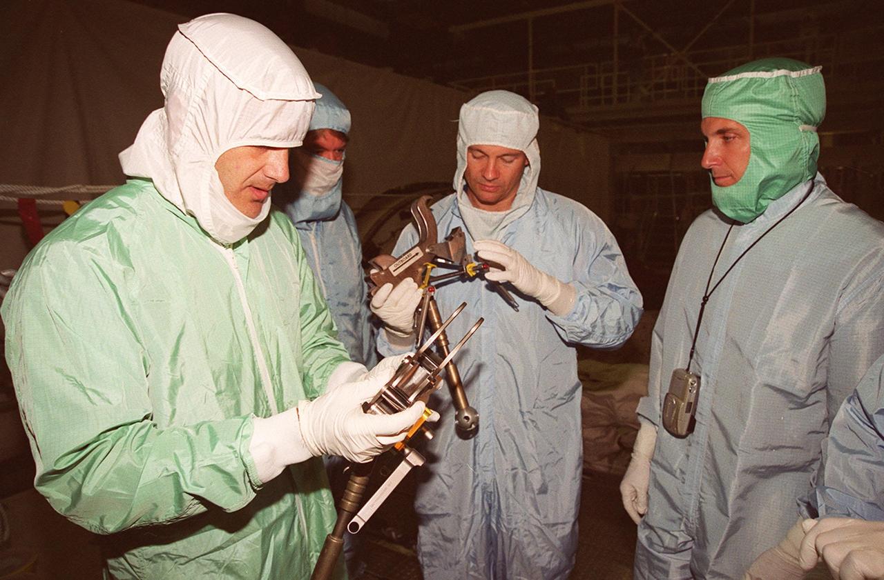 As part of Crew Equipment Interface Test activities, STS-92 Mission Specialists Jeff Wisoff (left) and Michael Lopez-Alegria (center) check equipment that they will be using on their mission. Boeing workers (second from left and right) look on. Other crew members taking part in the CEIT are Commander Brian Duffy, Pilot Pam Melroy, and Mission Specialists Koichi Wakata, Leroy Chiao and Bill McArthur. STS-92 is scheduled to launch Oct. 5 on Shuttle Discovery from Launch Pad 39A on the fifth flight to the International Space Station. Discovery will carry the Integrated Truss Structure (ITS) Z1, Pressurized Mating Adapter 3, Ku-band Communications System, and Control Moment Gyros (CMGs)