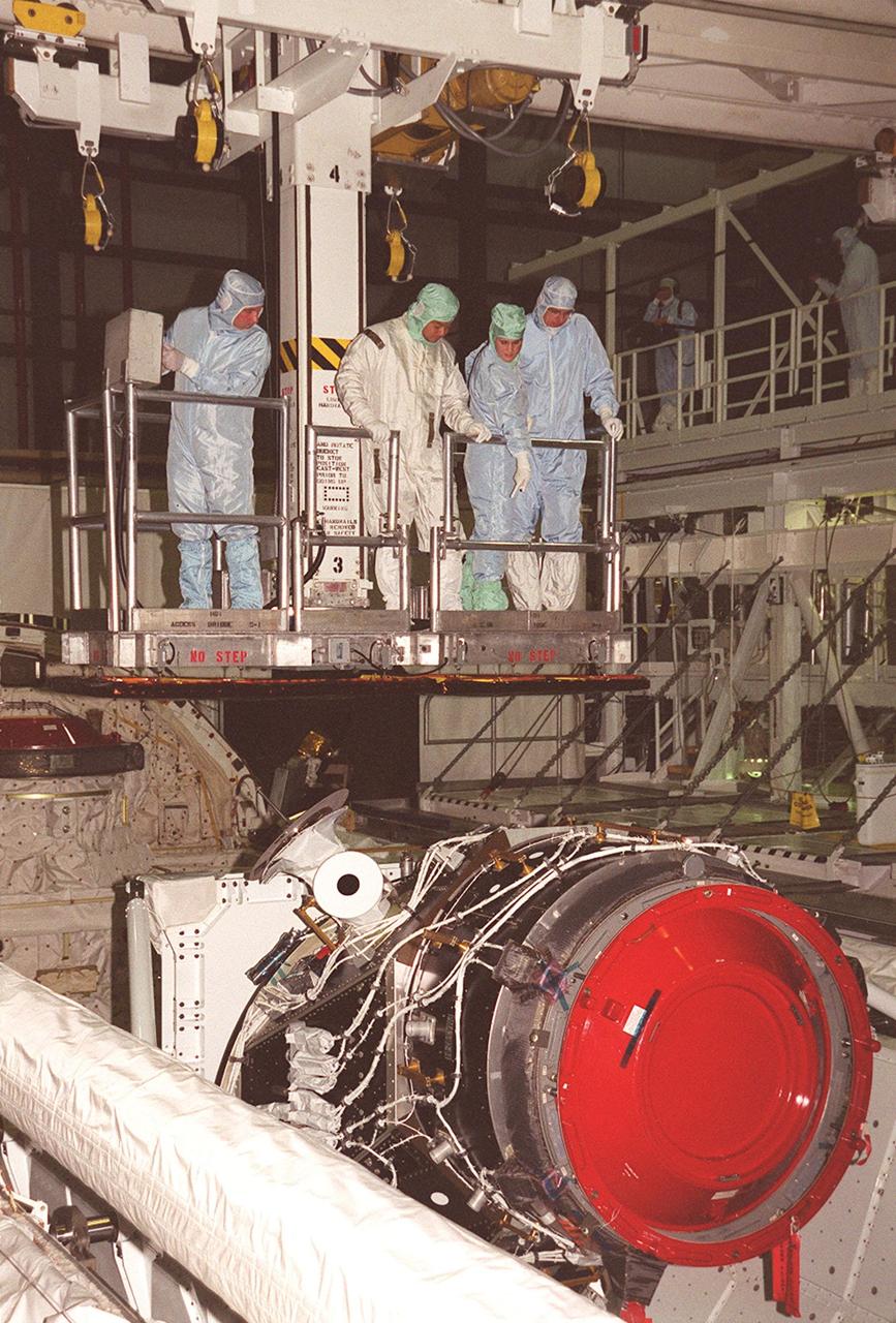 KENNEDY SPACE CENTER, FLA. -- Being lowered into the payload bay of Discovery for a closer look at the payload are STS-92 Mission Specialists Leroy Chiao (second from left) and Bill McArthur (far right), accompanied by Boeing workers. In the foreground is the Pressurized Mating Adapter-3. They and other crew members Commander Brian Duffy, Pilot Pam Melroy and Mission Specialists Koichi Wakata, Jeff Wisoff and Michael Lopez-Alegria are taking part in Crew Equipment Interface Test activities. STS-92 is scheduled to launch Oct. 5 on Shuttle Discovery from Launch Pad 39A on the fifth flight to the International Space Station. Discovery will carry the Integrated Truss Structure (ITS) Z1, the PMA-3, Ku-band Communications System, and Control Moment Gyros (CMGs)