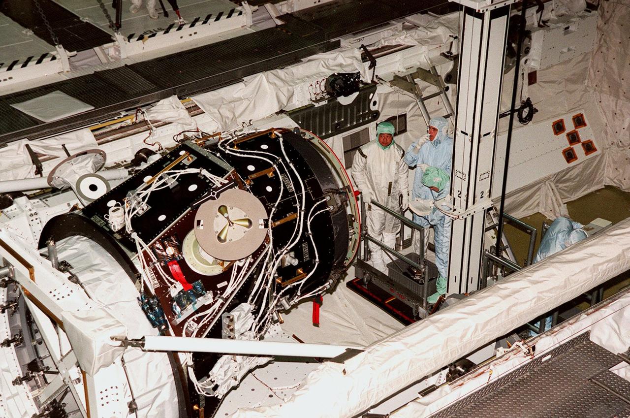 KENNEDY SPACE CENTER, FLA. -- On a platform inside the payload bay of Discovery, STS-92 Mission Specialists Leroy Chiao and Bill McArthur take a close look at Pressurized Mating Adapter-3 (PMA-3). They and other crew members Commander Brian Duffy, Pilot Pam Melroy and Mission Specialists Koichi Wakata, Jeff Wisoff, and Michael Lopez-Alegria are at KSC to take part in Crew Equipment Interface Test activities. Discovery is in the Orbiter Processing Facility bay 1. STS-92 is scheduled to launch Oct. 5 on Shuttle Discovery from Launch Pad 39A on the fifth flight to the International Space Station. Discovery will carry the Integrated Truss Structure (ITS) Z1, the PMA-3, Ku-band Communications System, and Control Moment Gyros (CMGs)